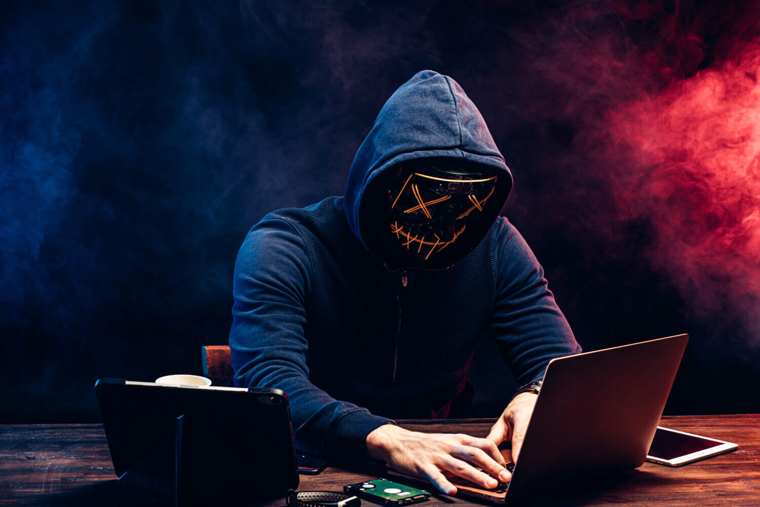a man with a mask sitting in front of the computer