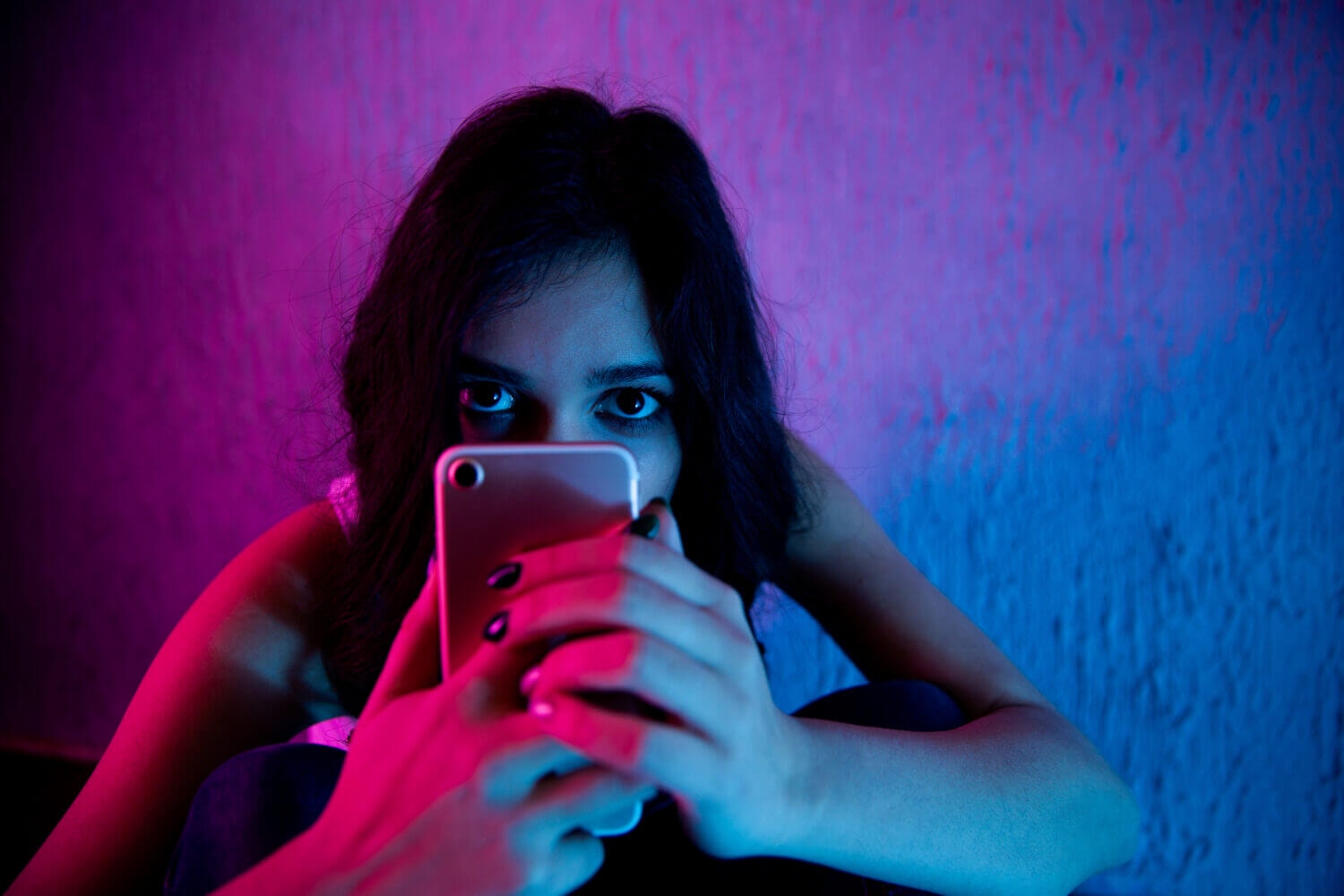 woman with a phone in a dark setting